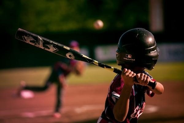 A child prepares to swing at a pitch during baseball training