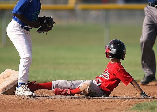 Young baseball player slides into a base